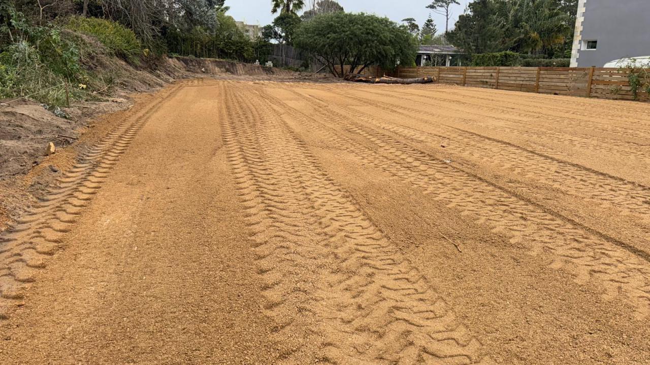 Plataforma compactada con marcas de rodado y el talud del corte a un costado